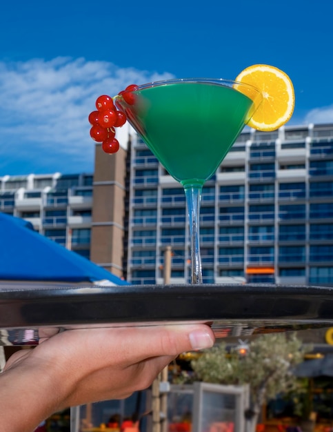 Cocktail blue curacao green currant orange sand beach sea hand tray waiter