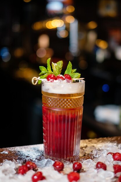 Cocktail decorated with berries and mint on the bar The concept of the correct preparation of drinks