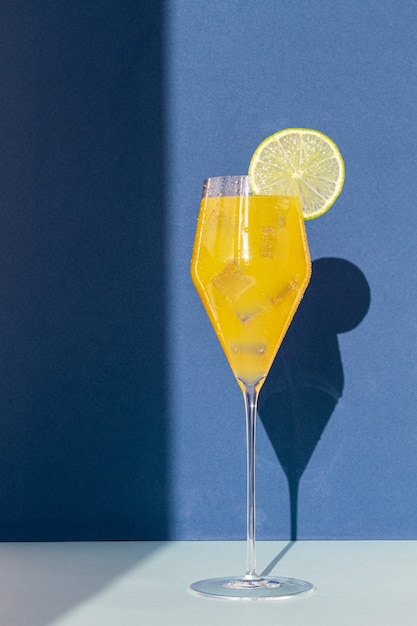 Cocktail in a glass with colored backgrounds and shadows on the wall