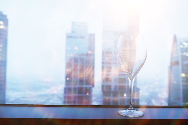 Cocktail glasses on the windowsill by the glass of a tall building