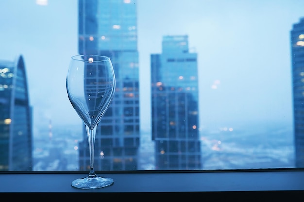 Cocktail glasses on the windowsill by the glass of a tall building