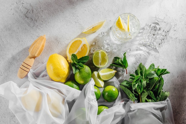 Cocktail making. Mint, lime, lemons ice ingredients and bar utensils. Flat lay, top view.