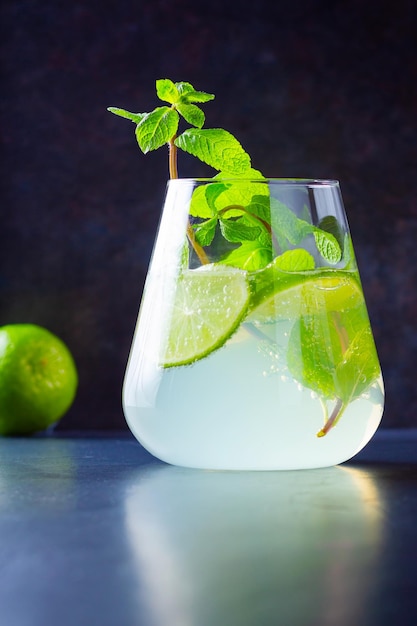 Cocktail mojito with lime and mint in glass One glass of mojito on a dark background