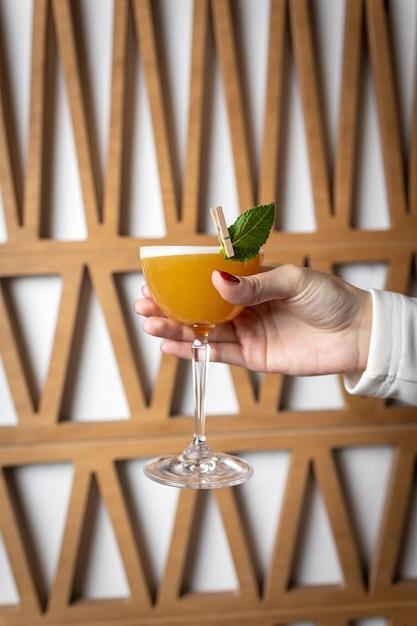 Photo cocktail with orange and mint in the hands of a woman