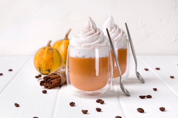 Cocktail with whipped cream on top on white wooden table