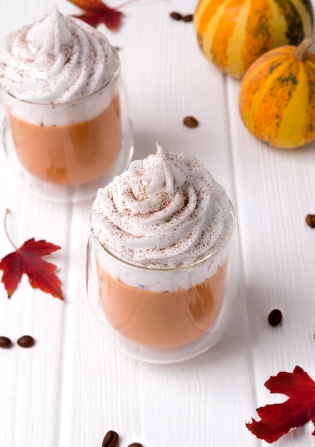 Cocktail with whipped cream on top on white wooden table