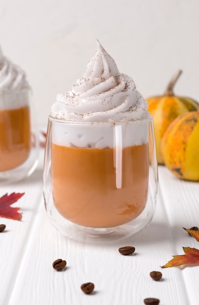 Cocktail with whipped cream on top on white wooden table