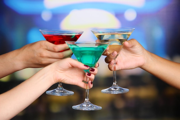 Cocktails in hands in nightclub