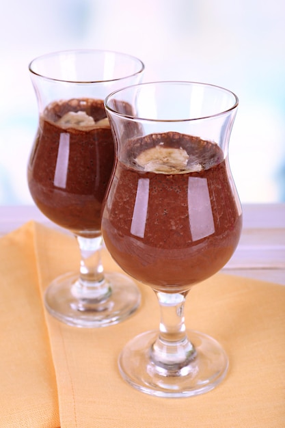 Cocktails with banana and chocolate on table on light background