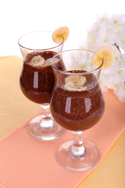 Cocktails with banana and chocolate on table on white background