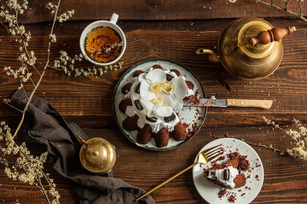 Cocoa cake and tea cup with teapot on wooden table