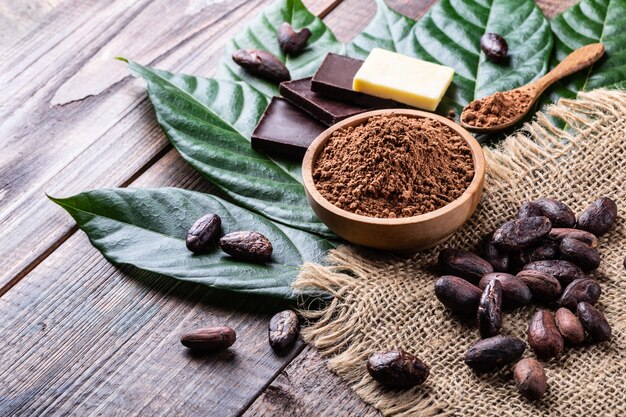 Cocoa products for making home chocolate on old rustic table 