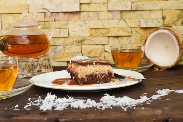 Coconut Cake on white plate with a spoon and caramel sauce