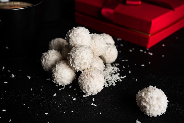 Coconut candies with nuts on dark background Raffaello on black background High quality photo