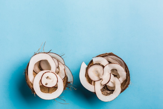 Coconut chips in a bowl of coconut on a blue 