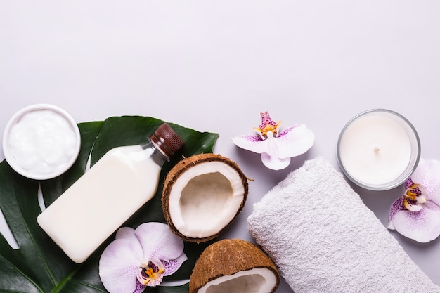 Coconut cosmetic product, tropical leaves and flowers. Natural spa concept.