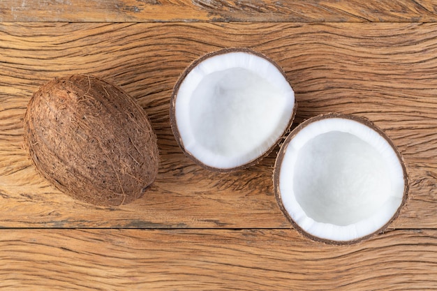 Coconut and cracked half fruit over wooden table