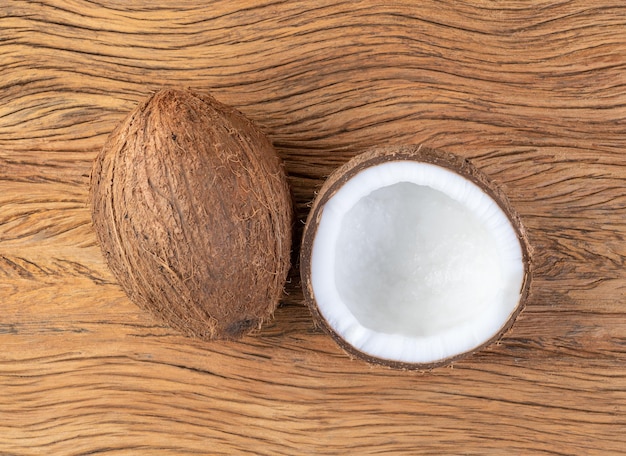 Coconut and cracked half fruit over wooden table