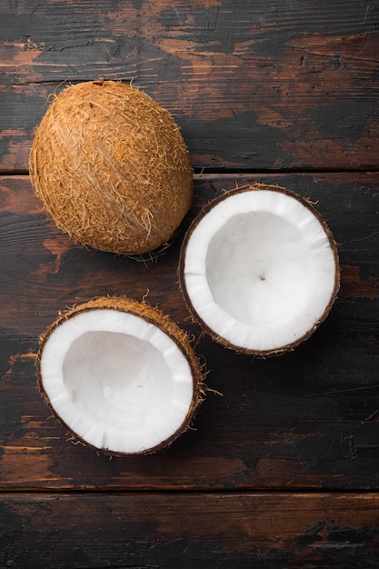 Coconut cuts broken on old dark wooden table background top view flat lay