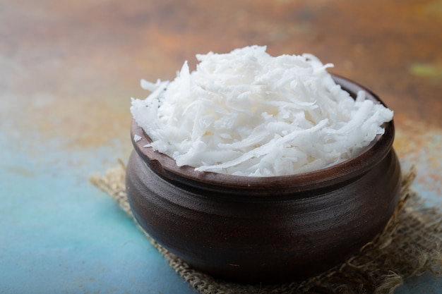 Coconut flakes in a clay bowl.