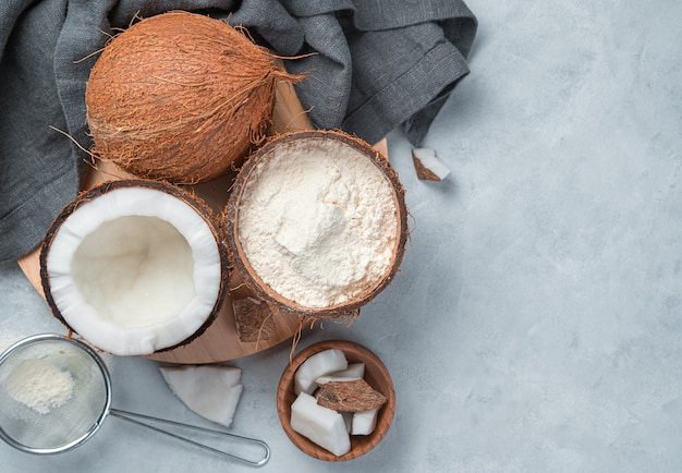 Coconut flour and coconut on a gray background. Top view, copy space.