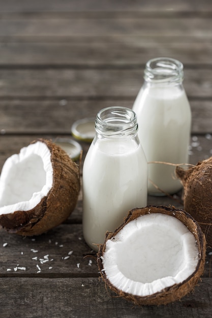 Coconut kefir in bottles on wooden table. Vegan non dairy healthy or fermented drink. Healthy eating concept