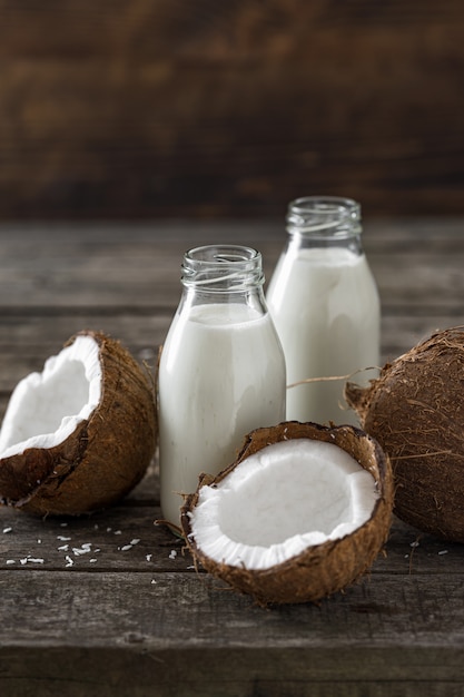 Coconut kefir in bottles on wooden table. Vegan non dairy healthy or fermented drink. Healthy eating concept