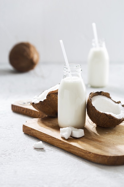 Coconut kefir in glass bottle on wooden table. Vegan non dairy healthy or fermented drink. Healthy eating concept