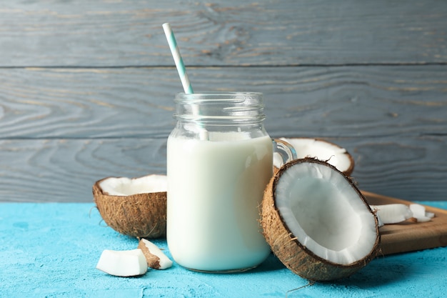 Coconut and milk on blue table, close up