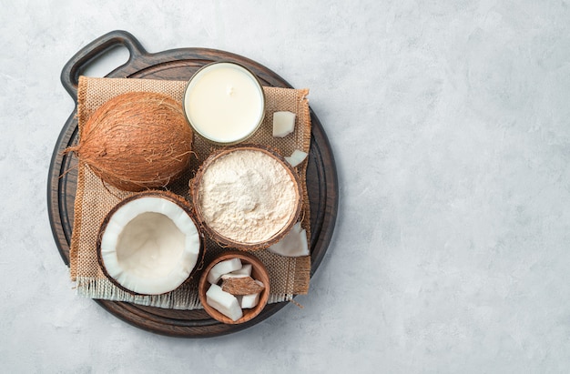 Coconut milk, flour and coconut on a gray background. Top view, copy space.