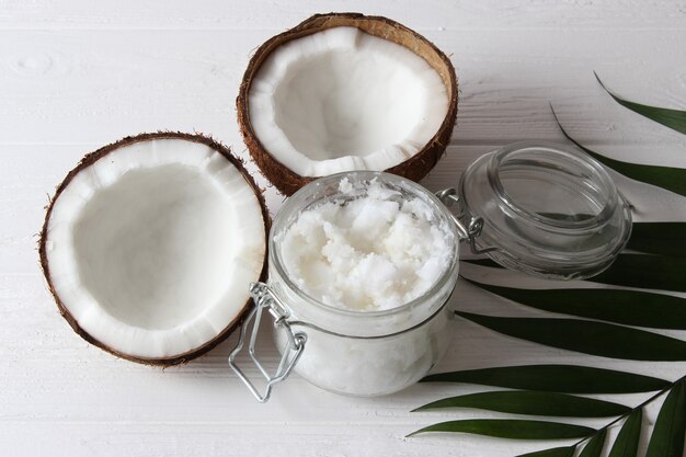 Coconut oil and coconuts, palm branches close up. High quality photo