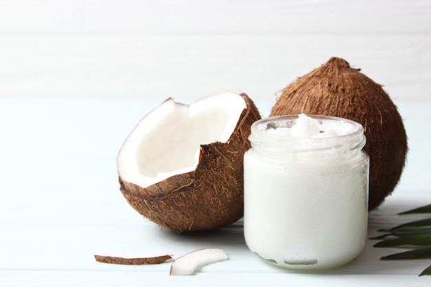 Coconut oil and coconuts palm branches close up