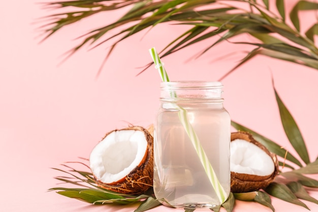 Coconut water and coconuts on a bright pastel