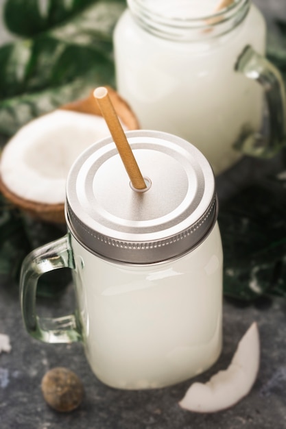 Coconut water drink in glass jar with handle close up