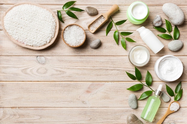 Coconut with jars of coconut oil and cosmetic cream on colored background Top view Free space for your text Natural spa coconut cosmetics and organic treatment concept Coconut Spa composition