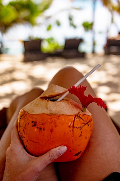 coconut in woman hands on the background of the sea the concept of summer holidays and vacations