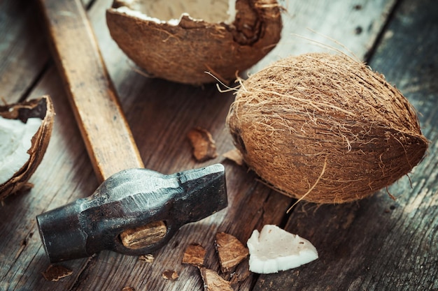 Coconuts and hammer on old wooden table