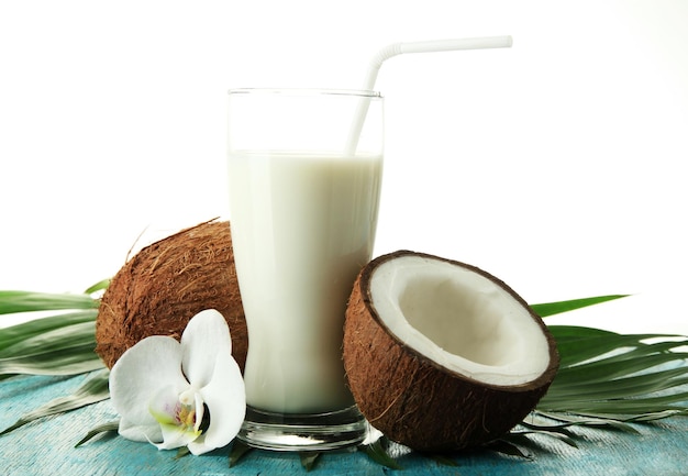 Coconuts with glass of milk on blue wooden background