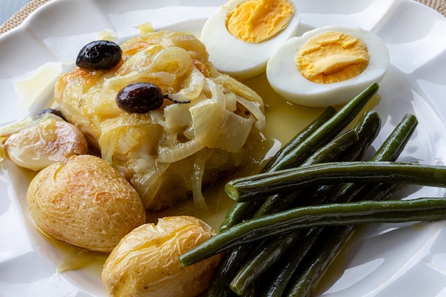 Cod loin baked in olive oil, with potatoes, broccoli, boiled egg and black olives. Typical dish of Portugal.