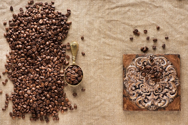 Coffee background. Coffee beans on burlap and brass scoop