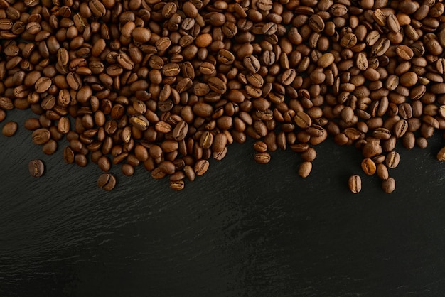 Coffee beans black background Beautiful coffee background Roasted coffee beans on black stone table