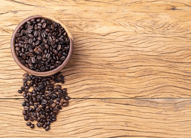 Coffee beans on a bowl over wooden table with copy space