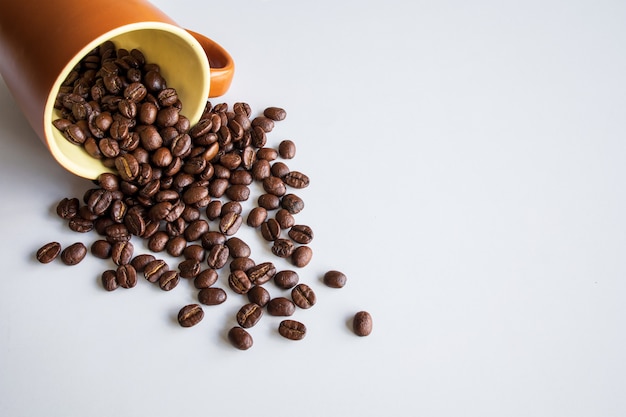 Coffee beans in brown glass on white table background. top view. space for text