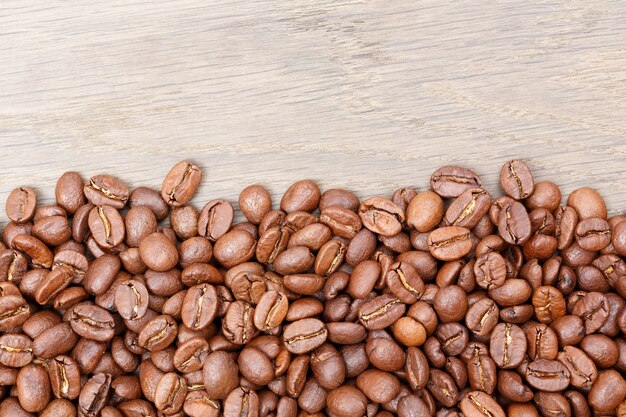 Coffee beans on the brown wooden background. High resolution photo.