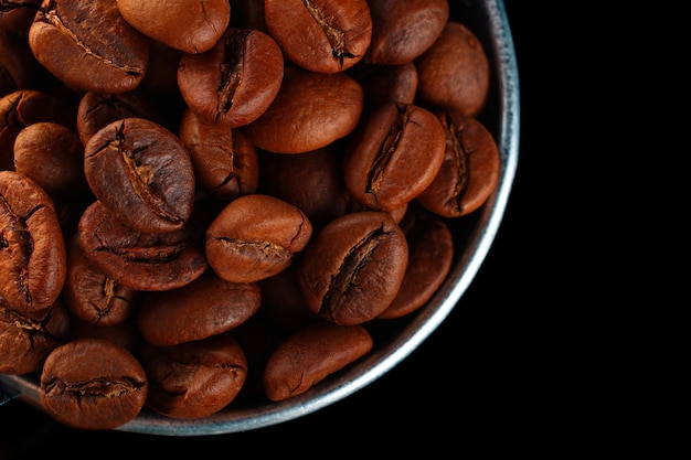 Coffee beans in a bucket on a dark background