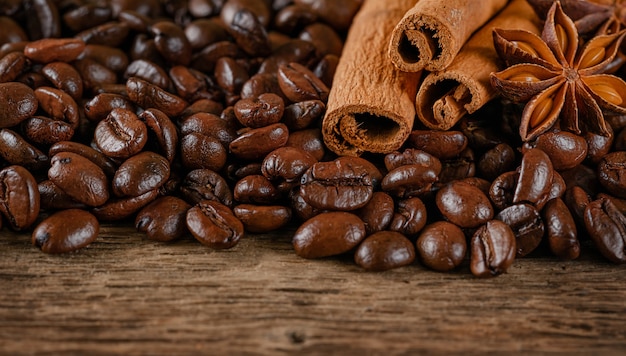 Coffee beans, cinnamon and anise on wooden table. Close up, copy space