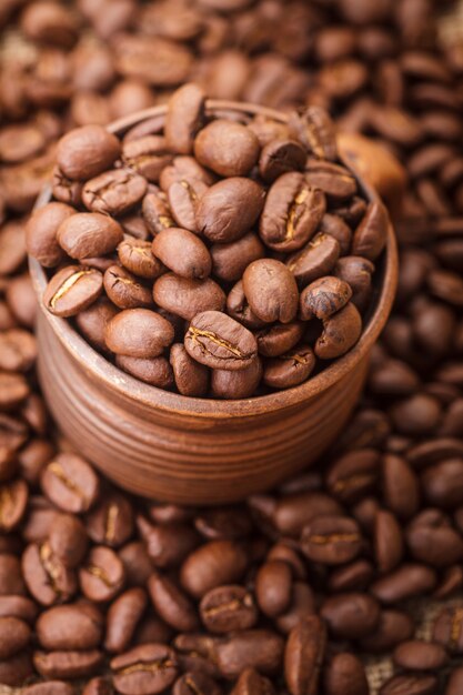 Coffee beans in the clay cup close up