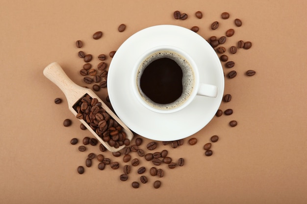 Coffee beans and coffee cup on colored background with place for text