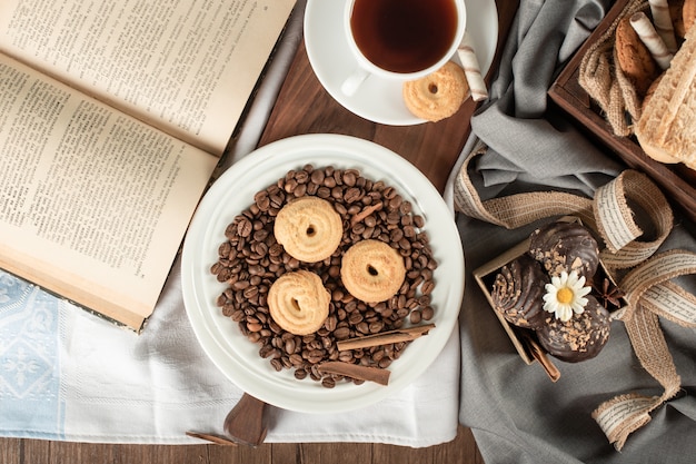 Coffee beans, cookie, pralines and a cup of tea