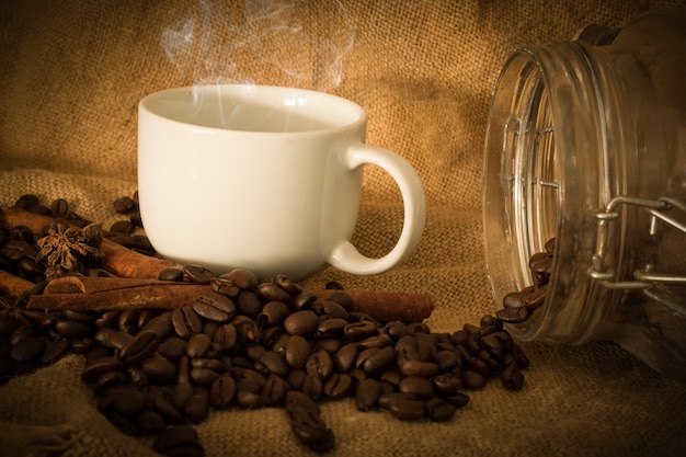 Coffee beans and cup coffee on the cloth sack select focus, Vintage color tone or dark tone